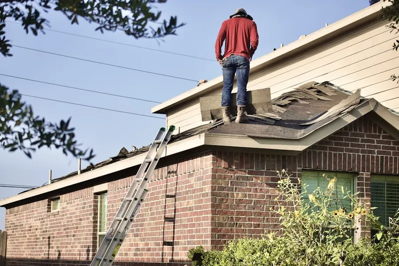 Professional roofer working on a residential roof in Rochester Mills